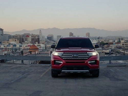 2024 Ford Explorer parked outside a city at dusk with headlights on