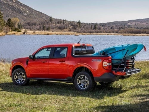 2024 Ford Maverick parked next to a lake with a kayak in the bed of the truck