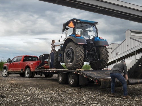 2024 Ford Super Duty towing a large tractor on a trailer
